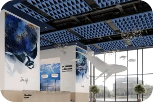 Modern collaborative workspace featuring suspended Acoufelt Gills Salmon Ceiling Frames in Marine blue for biophilic texture and targeted acoustic control